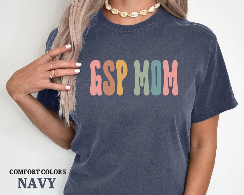 a woman wearing a navy tshirt with the word g is for mom printed