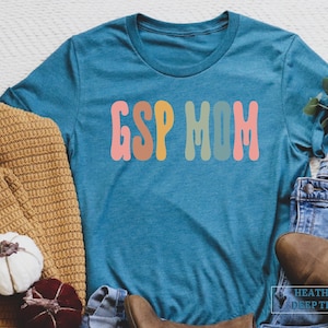 a t - shirt that says esp mom next to a pair of jeans and