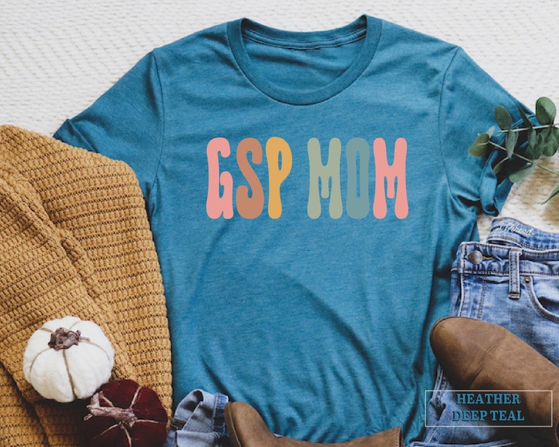 a t - shirt that says esp mom next to a pair of jeans and