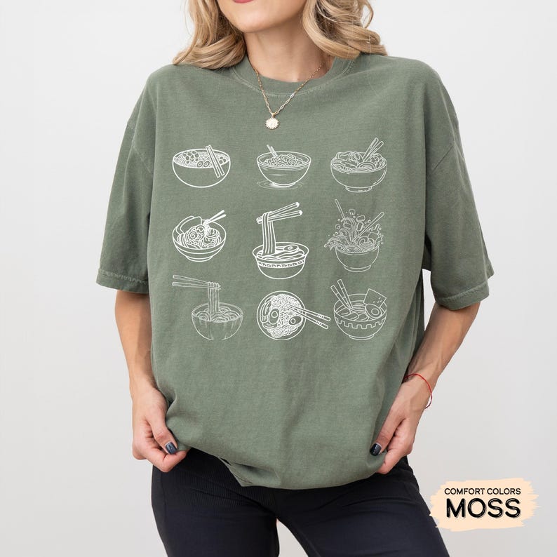 May include: A green t-shirt with a white graphic of nine bowls of ramen noodles. The shirt has the words "COMFORT COLORS" and "MOSS" printed on the bottom right corner.