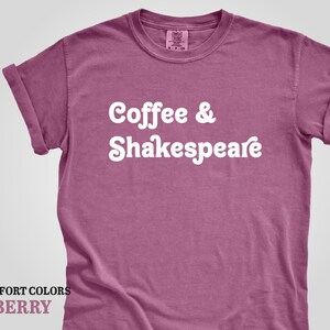 May include: A berry colored t-shirt with the text "Coffee & Shakespeare" in white.