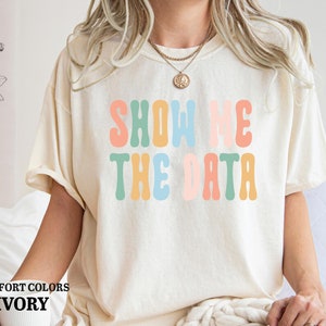 a woman wearing a t - shirt that says show me the data