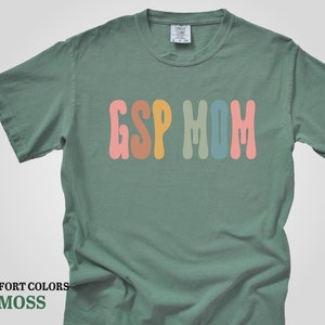 a green t - shirt with the word g s p m on it