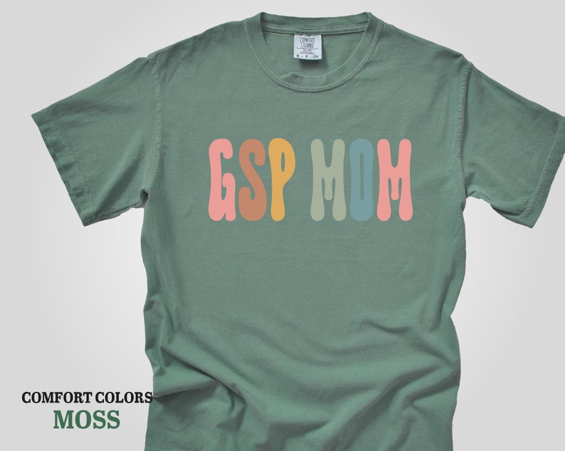 a green t - shirt with the word g s p m on it