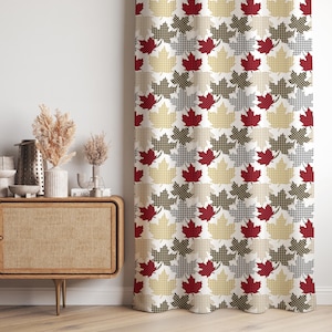 May include: A patterned curtain with a repeating maple leaf design. The leaves are red, grey, and black, set against a cream and white checkered background. The curtain is made of a thick fabric.