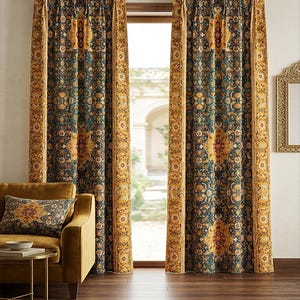 May include: Two ornate, patterned curtains in shades of teal, gold, and brown hang on a gold rod. The curtains feature a central medallion design and a decorative border. A gold-colored sofa and pillow are visible.