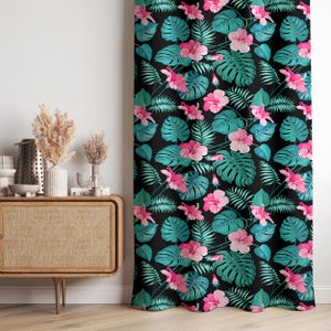 May include: A black curtain with a tropical floral pattern. The design features large pink hibiscus flowers, teal monstera leaves, and green fern leaves. The curtain is likely made of a soft fabric.