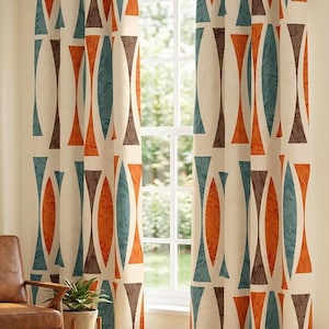 May include: Cream-colored window curtains with a repeating geometric pattern in orange, teal, and brown. The design features elongated shapes and triangles. The curtains are hanging in front of a window, with a glimpse of a chair and a plant.