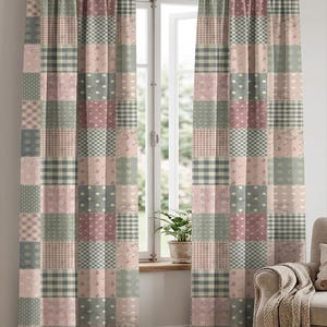 Op de afbeelding: Patchwork gordijnen in roze, groen en grijs. De gordijnen hebben een herhalend patroon van vierkanten met verschillende ontwerpen, waaronder stippen, ruitjes en bloemenprints. De gordijnen hangen voor een raam.