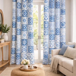 May include: A pair of floor-length curtains featuring a repeating blue and white tile pattern with floral motifs. The curtains are hung on a dark metal rod with grommets, displaying a vertical arrangement of square tiles across the fabric panels.