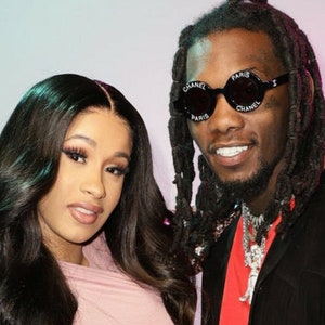 Puede incluir: Una mujer con el pelo largo y negro y una blusa rosa se encuentra junto a un hombre con rastas largas que lleva una chaqueta negra y gafas de sol con el texto "CHANEL PARIS" en las monturas.