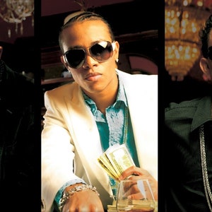 May include: Three men wearing sunglasses and gold chains. The man in the middle is wearing a white suit jacket and holding a stack of cash. The man on the left is wearing a black jacket and a red shirt. The man on the right is wearing a black shirt.