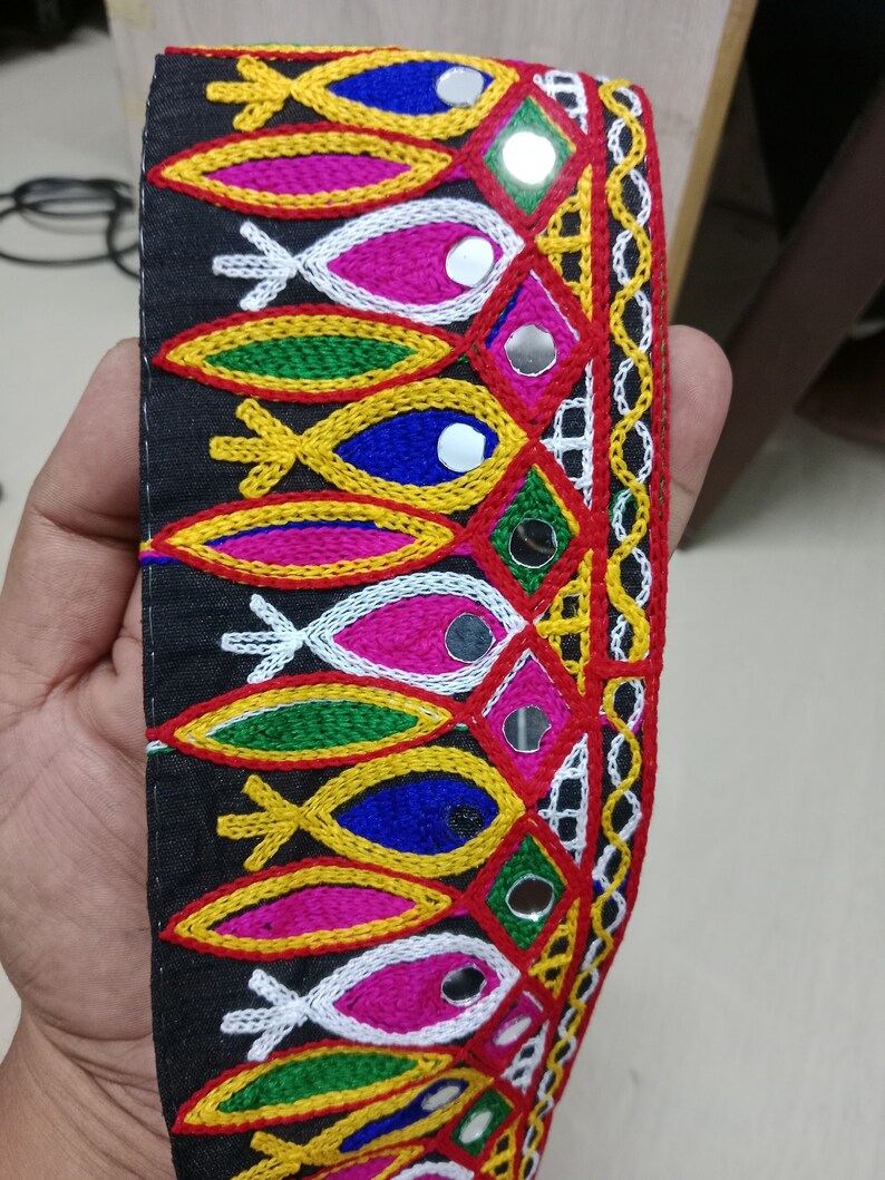 May include: Black fabric trim with colorful embroidered fish shapes and silver mirror accents.