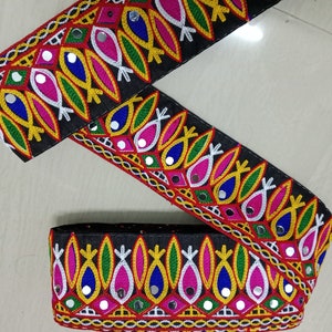 May include: Black fabric trim with colorful embroidery and mirrored accents. The trim features a repeating pattern of fish shapes, geometric designs, and small round mirrors.