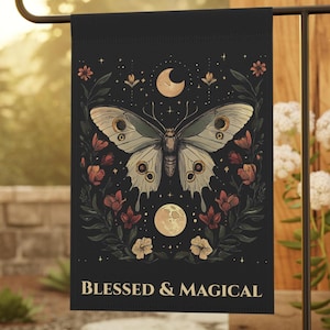 May include: Black garden flag with a butterfly design, cream wings, and floral and celestial motifs. The flag reads "BLESSED & MAGICAL". The flag is displayed on a black metal stand, suitable for outdoor use.