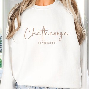 May include: White sweatshirt with the text "Chattanooga Tennessee" in brown script.