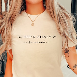 May include: A white t-shirt with the text "32.0809° N 81.0912° W - savannah" printed on the front.