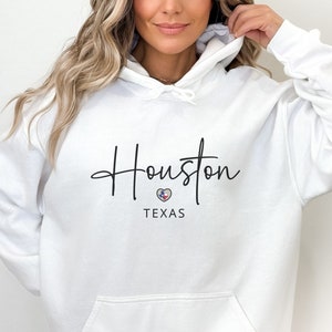May include: White hooded sweatshirt with the text "Houston, TEXAS" and a small heart with the Texas flag inside.