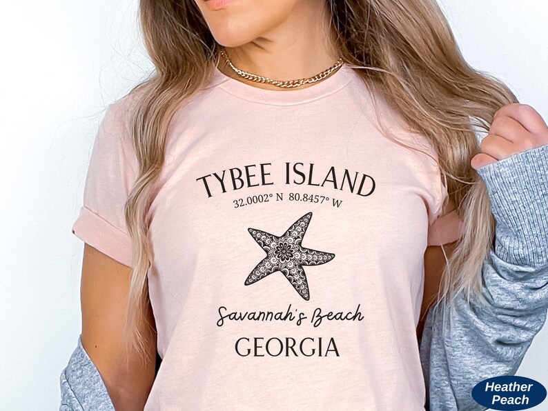 May include: A pink t-shirt with a black graphic design featuring a starfish and the text "Tybee Island 32.0002&deg; N 80.8457&deg; W Savannah's Beach GEORGIA".