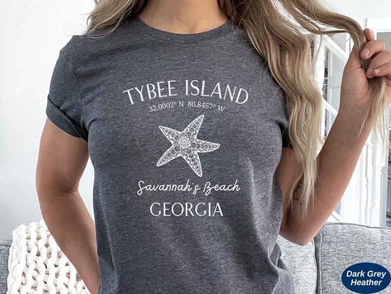 May include: Dark grey heather t-shirt with white text that reads "Tybee Island 32.0002&deg; N 80.8457&deg; W Savannah's Beach GEORGIA" and a white starfish graphic.