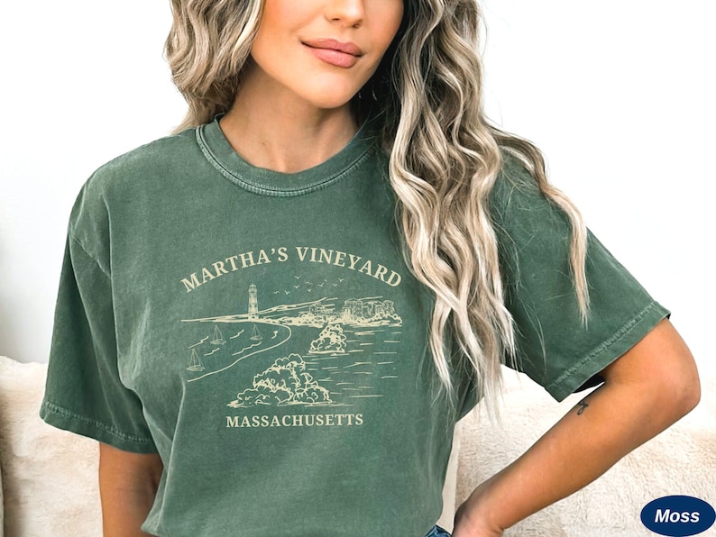 May include: A green t-shirt with a vintage look featuring a graphic of a lighthouse, beach, and the text "Martha's Vineyard Massachusetts".