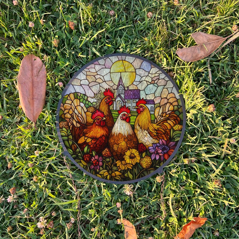 May include: A stained glass round wall decor featuring four colorful roosters and a church in the background. The roosters are surrounded by flowers and greenery.