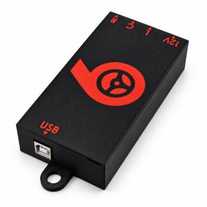 May include: A rectangular black electronic control box featuring a prominent red circular logo with a steering wheel icon. The top surface displays red text labels for 12V, L, C, R, and USB, with a USB port on the side and a mounting tab at the base.
