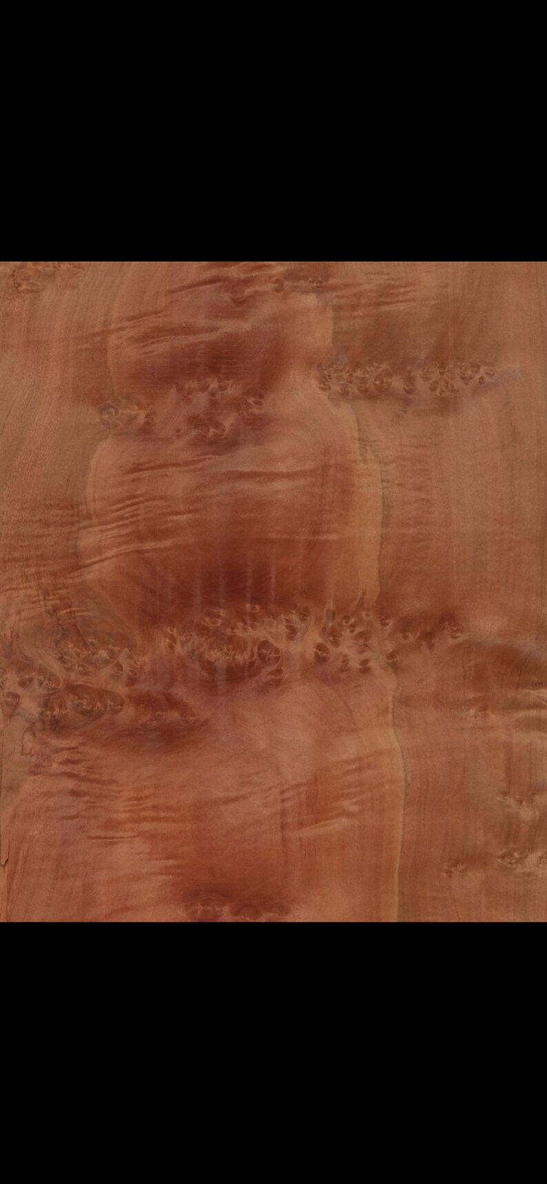 Peut inclure: Gros plan sur un placage de bois de couleur brun rouge&acirc;tre avec un motif de grain tourbillonnant.