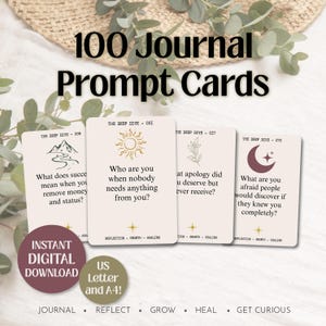 May include: A set of 100 journal prompt cards featuring off-white paper with black text and line art illustrations. Each card displays a unique question, a numbered header, and the text Reflection, Growth, Healing at the bottom of each card.