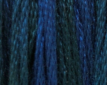 May include: A close-up of a bundle of embroidery floss in shades of blue and green. The floss is arranged in vertical rows and the text "Mermaid's Fin" is printed below the floss.