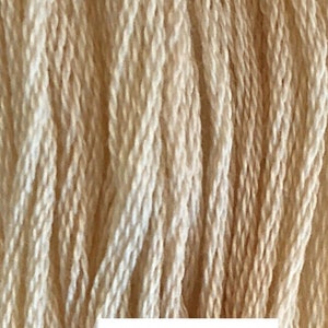 May include: Close-up of a bundle of Eggshell colored embroidery floss. The floss is made of cotton and is a light cream color.