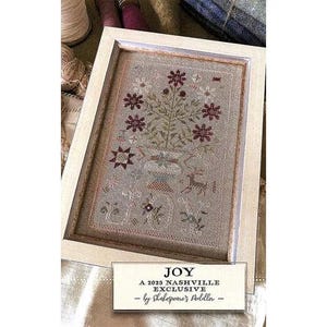 May include: A framed cross-stitch pattern with a floral design in shades of red, green, and brown. The pattern is titled "JOY" and is a 2023 Nashville Exclusive by Shakespeare's Peddler.