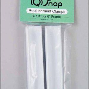May include: Two white plastic replacement clamps for a 6-inch picture frame. The clamps are 4 1/4 inches long. The packaging says "Genuine Q-Snap Replacement Clamps 4 1/4" for 6" Frame Made in USA".