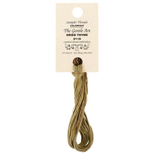 May include: A skein of green and brown embroidery floss labeled "Sampler Threads Colorfast by The Gentle Art Dried Thyme 0110 counted thread embroidery PO Box 670 New Albany, Ohio 43054"