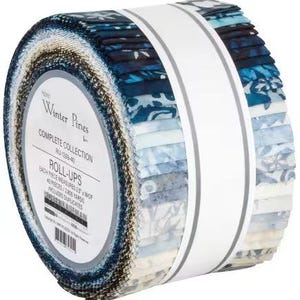 May include: A roll of Winter Pines fabric roll-ups. The fabric is a complete collection of 40 pieces, each measuring 6.35 cm wide. The fabrics feature a variety of blue and white patterns, and are held together with a white band.