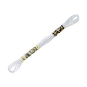 May include: A skein of white embroidery floss, with a label that reads "DMC 25". The floss is tightly wound and appears to be new. The label includes a barcode and the number "85200".