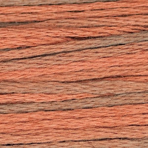 May include: Close-up of a skein of embroidery floss in shades of orange, brown, and gray. The threads are tightly wound and parallel, creating a textured surface. Ideal for cross-stitch and embroidery projects.