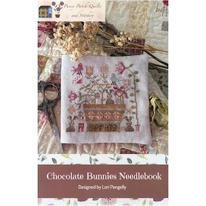 Può includere: Un quaderno per ricamo a punto croce con un motivo floreale e la parola "SPRING". Il quaderno è circondato da fiori secchi e forbici vintage. Il testo "Chocolate Bunnies Needlebook" è visualizzato in basso.