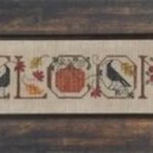 Peut inclure: Modèle de point de croix représentant le mot « Bienvenue » avec des images d'automne, notamment une citrouille, des oiseaux et des feuilles.