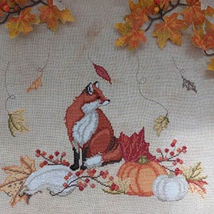 May include: Cross stitch pattern featuring a red fox sitting on a pile of gourds and pumpkins with fall leaves and berries.
