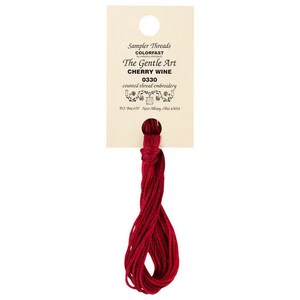 Puede incluir: Una bobina de hilo de bordar rojo con la etiqueta "Sampler Threads Colorfast The Gentle Art Cherry Wine 0330 counted thread embroidery PO Box 670 New Albany, Ohio 43054"