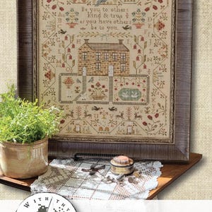 May include: A framed cross-stitch sampler featuring a central stone house, floral motifs, alphabet letters, and the text: Be you to others kind & true as you have others be to you. The design includes birds, deer, and the year 2025 in a brown wooden frame.