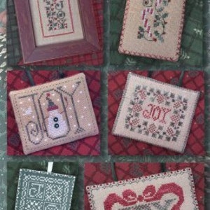 May include: Five cross-stitch patterns for holiday ornaments. The patterns feature the word "Joy" in different styles, including a snowman, a wreath, and a ribbon.