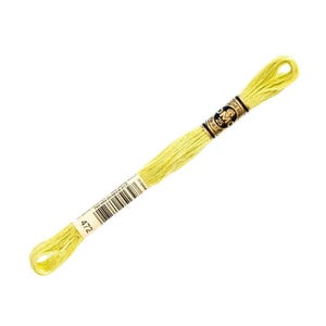May include: A skein of DMC 25 embroidery floss in a pale yellow-green color, labeled with the number 472. The floss is tightly wound and has a paper label with black text and a barcode. The DMC logo is visible.