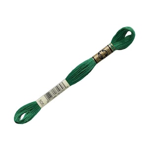 May include: A skein of emerald green embroidery thread, marked with the number 505. The thread is tightly wound and has a glossy finish. The label includes a barcode and the brand name.
