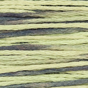 Op de afbeelding: Close-up van een klosje gevarieerd borduurgaren. Het garen is een mix van lichtgroen en donkerblauw.