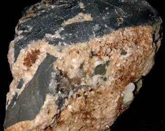 May include: A dark gray rock with a layer of light brown crystals on one side. The crystals are small and clustered together.