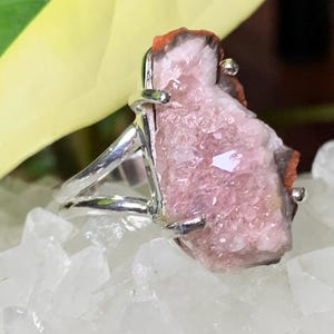 K&ouml;nnte beinhalten: Ein silberner Ring mit einem rosafarbenen und orangefarbenen Kristall, der in die Band gefasst ist. Der Kristall hat eine raue, nat&uuml;rliche Textur.