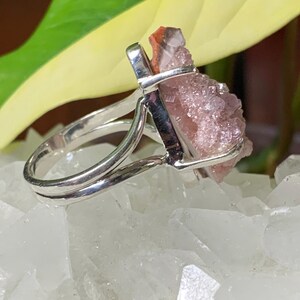 K&ouml;nnte beinhalten: Ein silberner Ring mit einem pinkfarbenen und roten Kristall in der Mitte. Der Kristall ist ein Cluster aus kleinen Kristallen.
