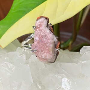 K&ouml;nnte beinhalten: Ein silberner Ring mit einem rosa und orangefarbenen Kristall. Der Kristall ist ein Cluster aus kleinen Kristallen.